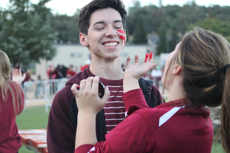 Max McDaniel gets his face painted by fellow senior Kaylee Guerra. Photo by Desi Kreiter