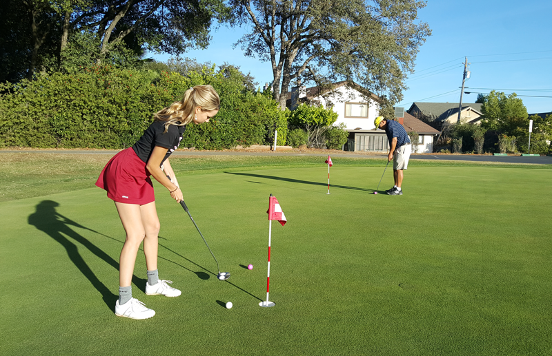 Maddie+Templeton%2C+a+sophomore%2C+practices+putting+with+Coach+Gayne+Nakano.+Photo+by+Bella+Batula