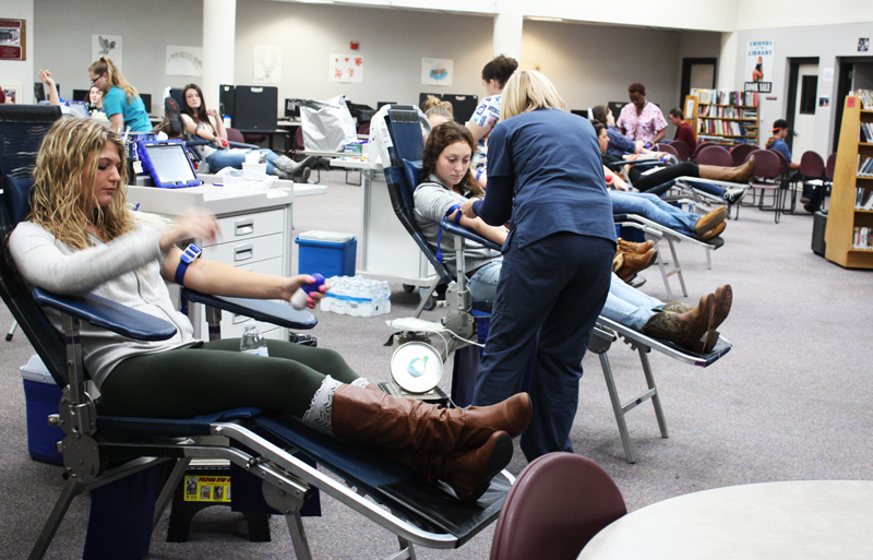 Senior Taylor Krogman gives blood in the library during the Blood Drive. Photo by Hailey Juergenson