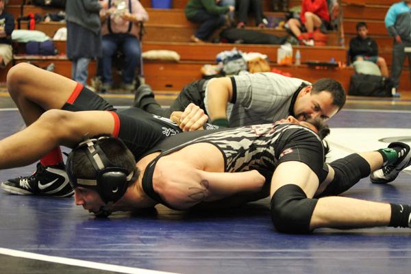Noah Danieli, a senior, takes down a competitor during a wrestling match. Photo by Jamie Danieli