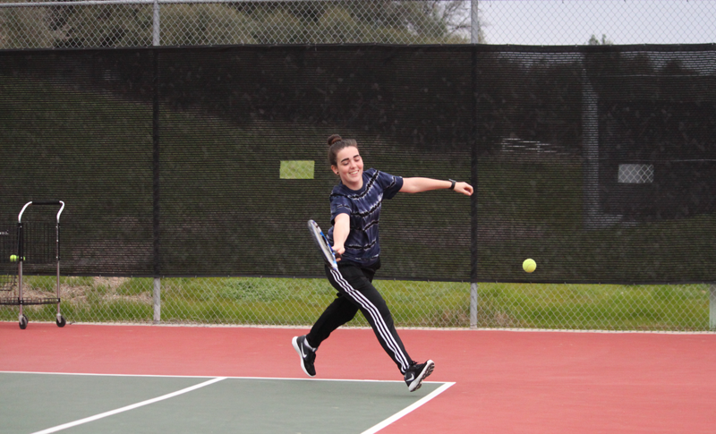 Breeze Davis, a senior, hits a tennis ball. Photo by Jared Pittsley
