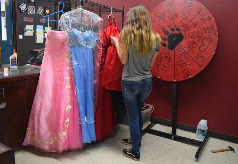Celeste Card, a junior, inspects donated prom dresses. Photo by Hailey Juergenson