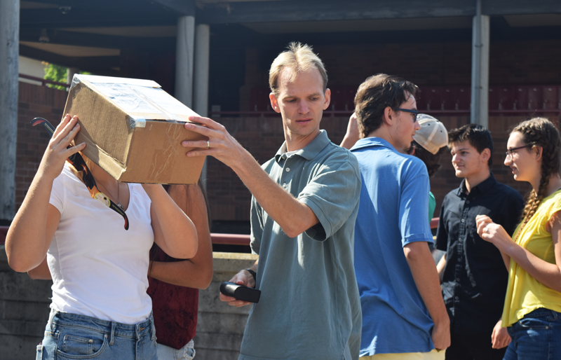Science Teacher Peter Gammelgard helps a student view the eclipse safely. Photo by Hailey Juergenson