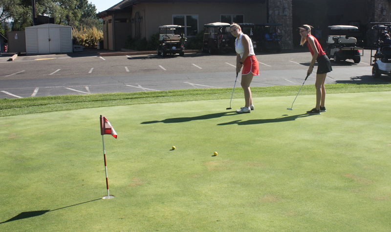 Senior Bella Batula and junior Maddie Templeton practice for the upcoming golf season. Photo by Kalei Owen