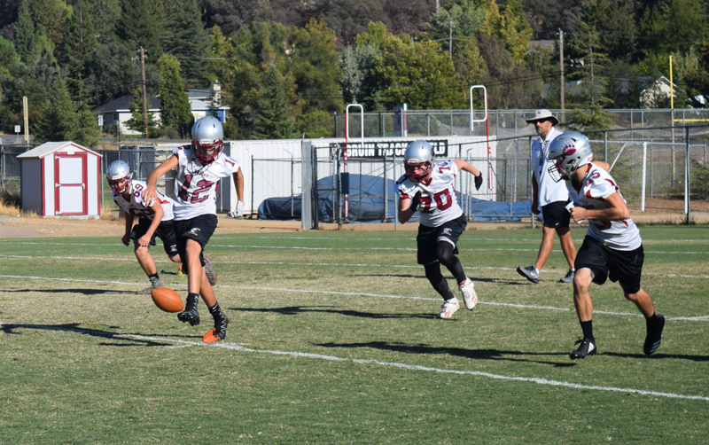 Junior Varsity football players Caleb Hurst, a sophomore, Colton Jenkins, a sophomore, Warren Davis, a freshman, and Erik LaCoss, a sophomore, practice kick-off. Photo by McKenna Hisaw 