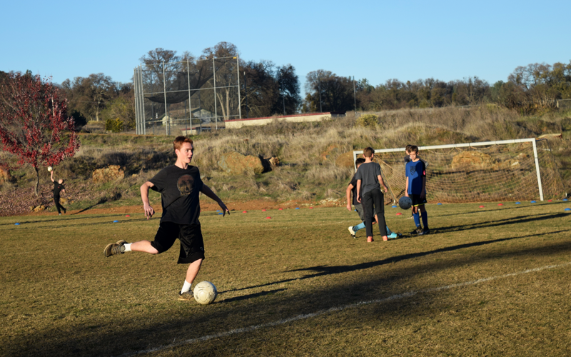 Soccer player Caden Corkery, a sophomore, kicks the ball during practice. Photo by McKenna Hisaw