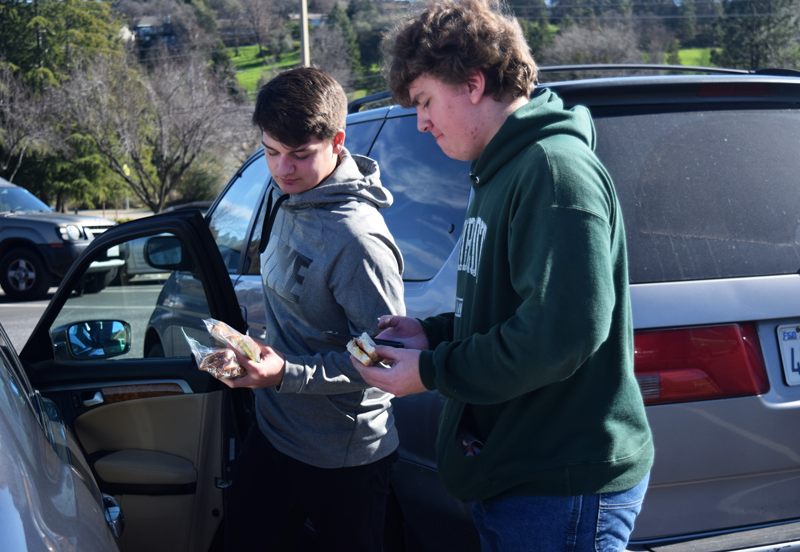 Juniors Tyler Cross and Grant Aubuchon socialize in their claimed parking spaces.
 Photo by Kalei Owen