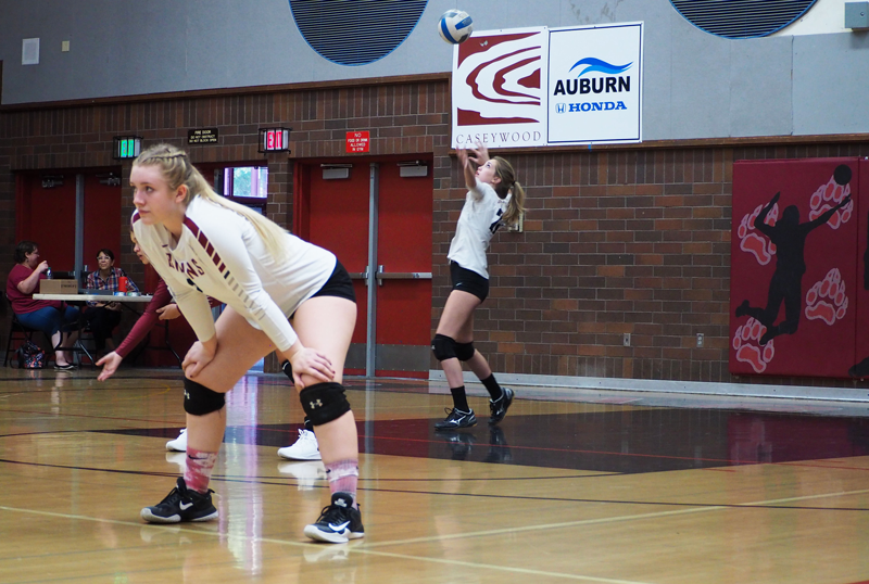 Sophomore Faith Phillips is ready while Sophomore Alexa Templeton serves the ball. Photo by Emily Bakey