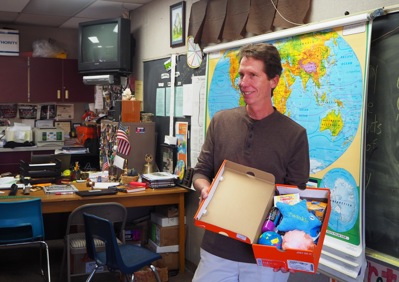 Key Club Supervisor Jeff Carrow shows his class the contents of one of the shoeboxes that he packed for Operation Christmas Child.  Photo by Zach Fink. 