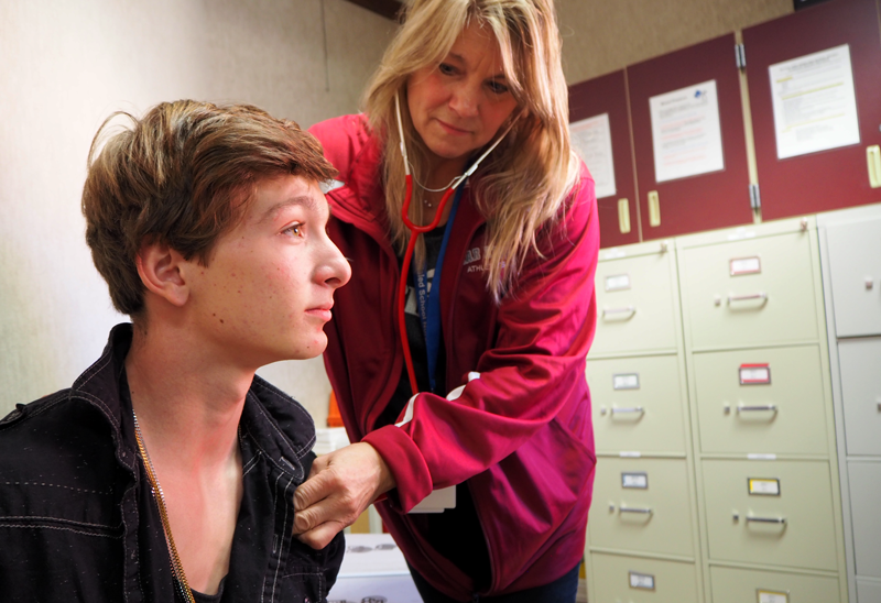 District Nurse Becky Bronswick checks on Sophomore Cody Ketchum. Photo by Bella Ferrari