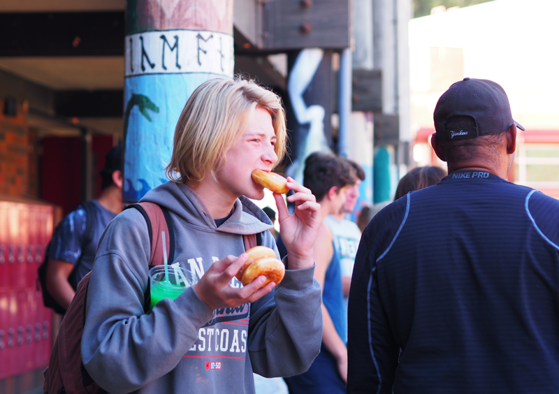 Freshman+Blake+Platzer+enjoys+several+delicious+doughnuts+during+Club+Rush.+Photo+by+Zach+Fink