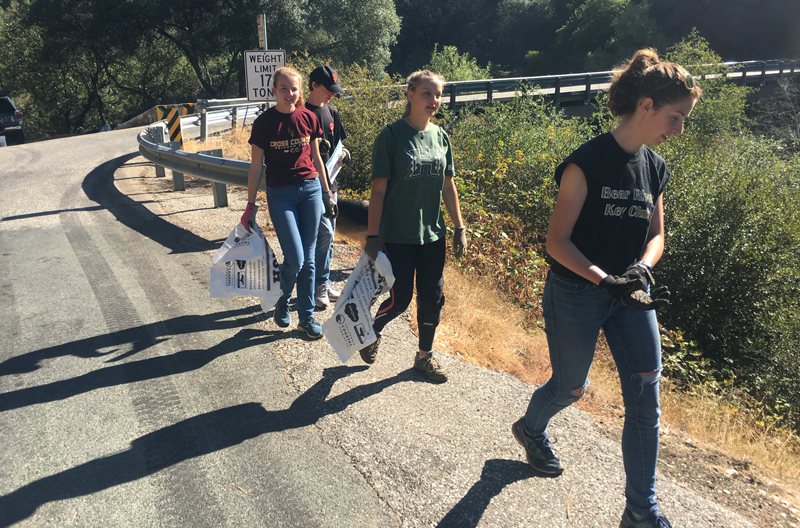 Seniors Grace Billingsley, Madita Hiller, Grace McDaniel, and Connor Ronka walk along the road looking for trash during the River Cleanup.  Photo by Sonora Slater. 