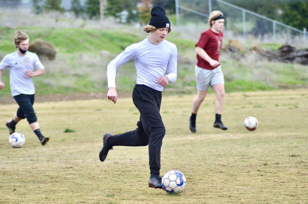 Varsity soccer player Paxton Waters practices drills during soccer practice on March 26th. Photo by Maya Bussinger