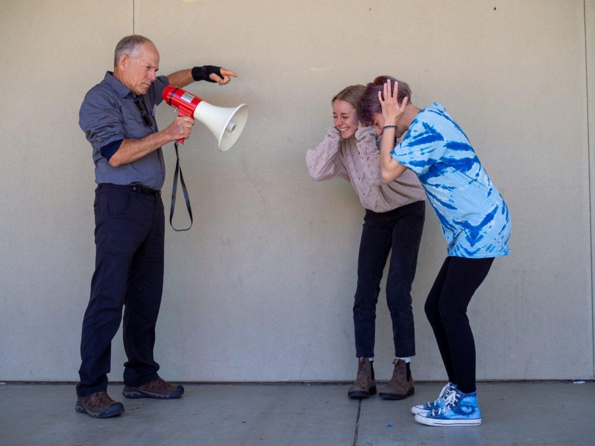  Mr. Bus makes an unexpected announcement to Liv DesAutels and Maya Cruz. Photo by Maya Bussinger