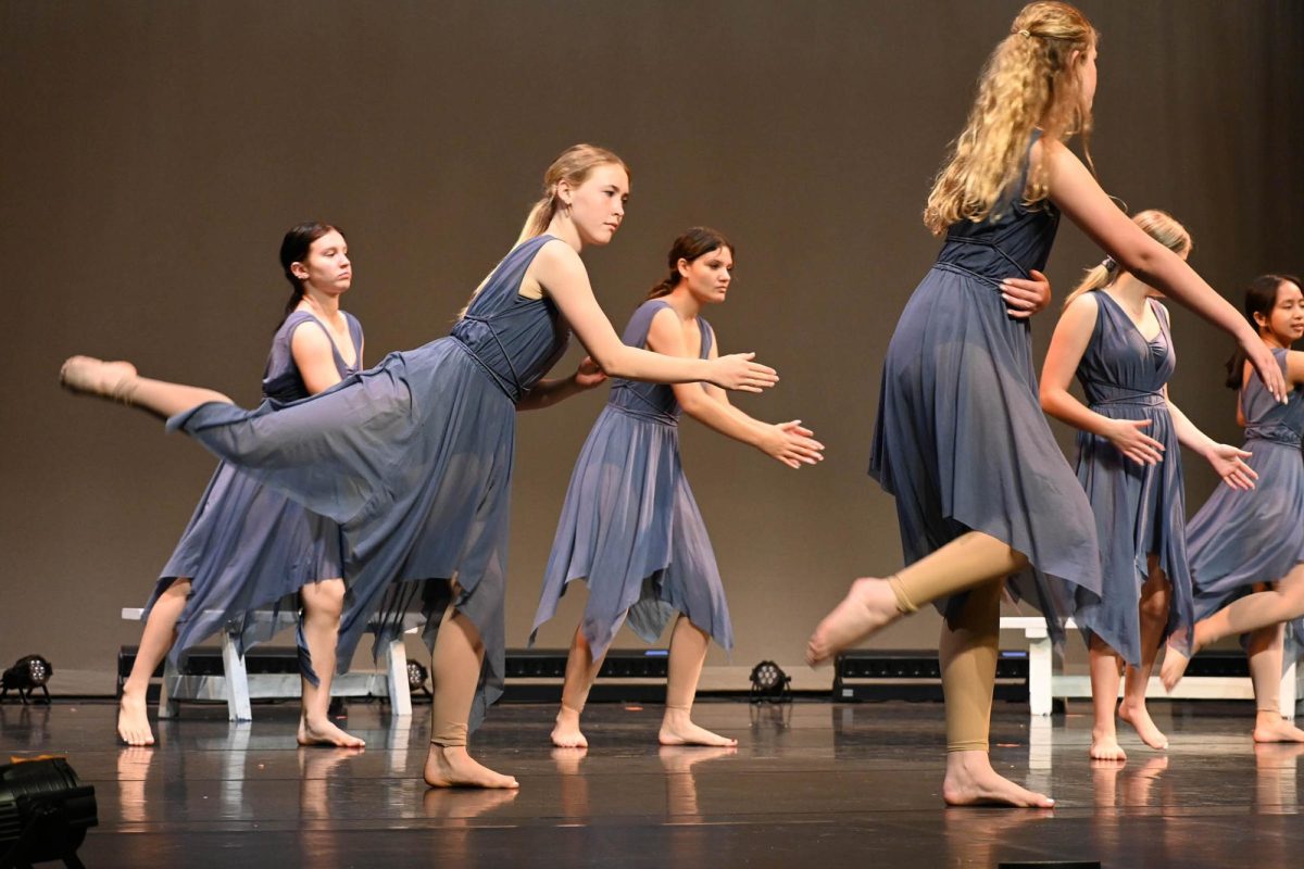 The beginning dance class practices their routine in the theater.